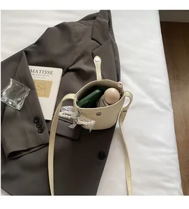 Interior view of beige bucket bag showing capacity for phone and folding umbrella