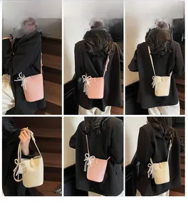 Detailed view of the elegant pearl bow and lace mesh on a bucket bag in soft colors