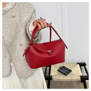 Détail du sac à main en cuir grainé rouge avec surpiqûres blanches et fermoir en T argenté