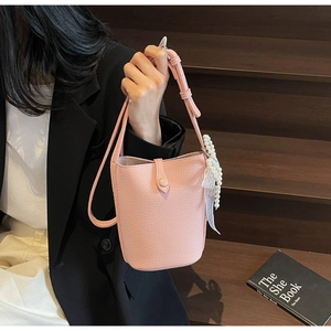 Pink lychee texture bucket bag with pearl and lace details in a lifestyle setting
