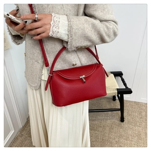 Détail du cuir rouge à grain litchi et du fermoir métallique argenté sur le sac à main