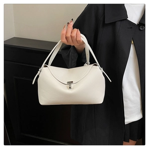 Détail d'un sac à main en cuir grainé blanc avec boucle en T argentée et deux poignées