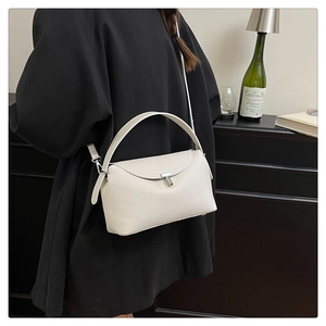 Vue détaillée du sac en cuir blanc crème avec fermoir en T et texture en cuir grainé doux