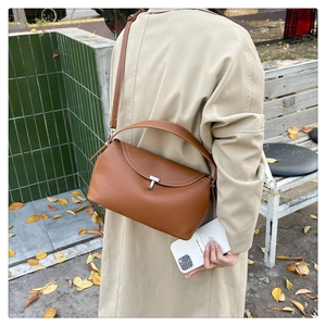 Détail du sac à main en cuir marron avec fermoir en T métallique et surpiqûres blanches