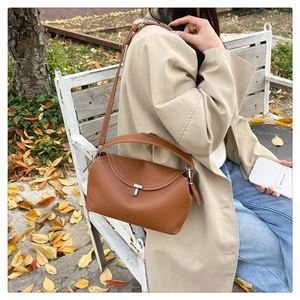 Sac en cuir caramel avec surpiqûres blanches et fermoir en T argenté en scène extérieure