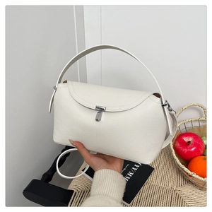 Détail du cuir litchi blanc et boucle argentée sur un grand sac à main élégant