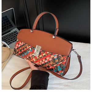 Detail of woven texture handbag with silver twist lock and colorful pattern design