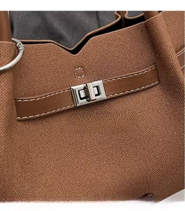 Dettaglio in pelle martellata marrone con fibbia in metallo argento e cuciture bianche