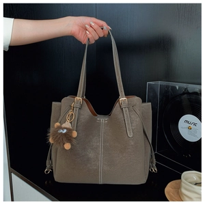 Dettaglio della borsa tote opaca color talpa con coulisse laterali e ciondolo a mostro
