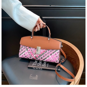 Close-up of tricolor woven texture and silver metal twist lock on a handheld bag