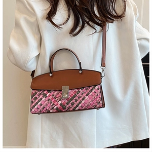 Close-up of a woven texture crossbody bag with contrast colors and leather strap