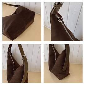 Detail view of brown suede hobo bag featuring wide green strap and silver ring zipper