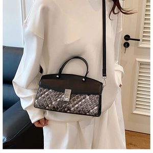 Detail of woven texture contrast handbag with silver buckle and thin shoulder strap