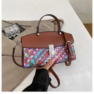 Detail of woven texture patchwork and metal lock on a vintage crossbody handbag