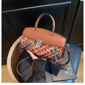 Close-up of woven crossbody bag with colorful texture, top handle, and silver buckle detail