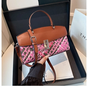 Detail of woven texture handbag with silver metal buckle and brown leather flap on a gift box
