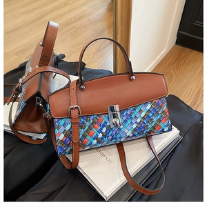 Macro view showing color-block woven texture and silver metal twist lock on the handbag