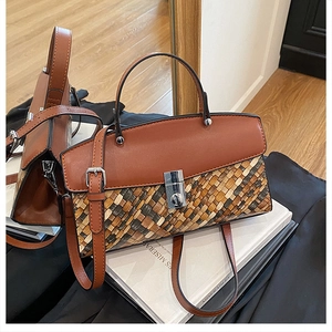 Close-up of contrast woven texture and silver metal buckle on brown crossbody bag