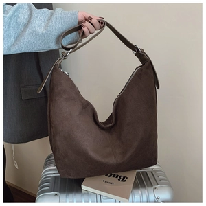 Detail of dark brown suede hobo bag with adjustable strap and silver zipper closure