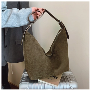 Macro view of high-capacity olive green suede crossbody bag showing rich texture and stitching
