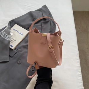 Pink leather bucket handbag with adjustable strap and metallic buckle for women