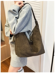 Detailed view of deep brown suede hobo bag with silver zipper and adjustable strap