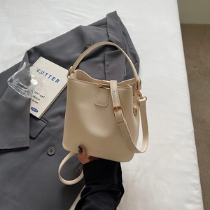 Chic cream white leather bucket bag with top handle and adjustable shoulder strap