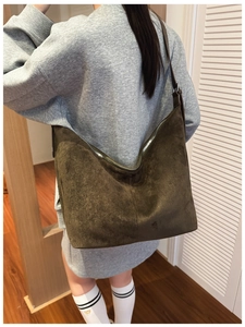 Close-up of deep brown suede Hobo shoulder bag with silver metal zipper and leather strap
