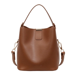 Brown minimalist leather bucket bag with top handle and gold-tone strap buckle detail