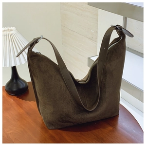 Detail of deep brown suede hobo bag with adjustable strap and silver metal buckle