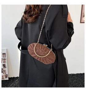 Détail du sac à main ovale léopard avec poignée dorée et bandoulière chaîne