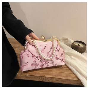 Detail of pink satin evening bag with cherry blossom embroidery and pearl handle