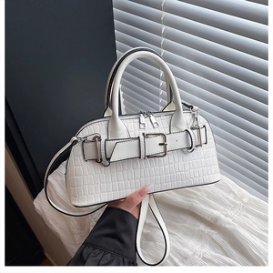 Detail of white crocodile pattern shell bag with silver buckle and adjustable shoulder strap