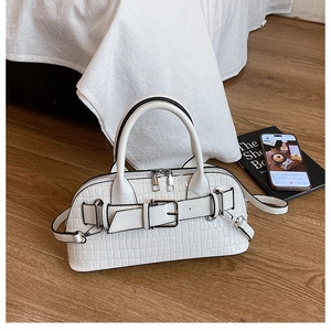 Detail of white crocodile pattern shell bag with buckle strap and silver hardware