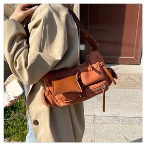 Detail view of retro caramel brown suede and leather patchwork crossbody bag with pockets
