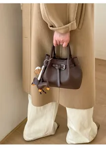 Detailansicht der braunen Handtasche aus Leder mit Gürtelschnalle und Hundeanhänger