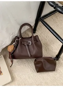 Braunes Taschen-Set mit Litschi-Struktur und Gürtelschnalle in wohnlichem Ambiente