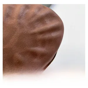 Macro d'un cuir mat marron avec une texture plissée naturelle et un toucher très doux