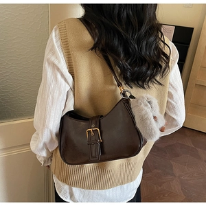 Dark brown glossy leather underarm bag with metal buckle and soft plush charm pendant