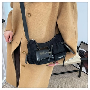 Detail of black crossbody bag with mixed suede and patent leather texture and silver zippers