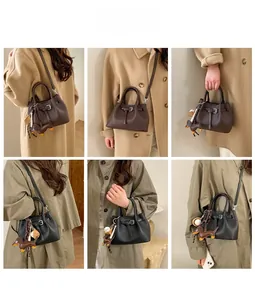 Trendige Leder-Beuteltasche mit Gürteldetail und süßem Enten-Anhänger am Schultergurt
