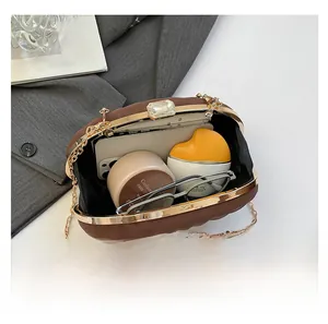 Vue intérieure du sac plissé marron montrant l'espace pour téléphone et maquillage