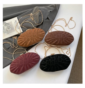 Détail de quatre pochettes ovales à texture léopard avec poignées en métal doré et chaînes