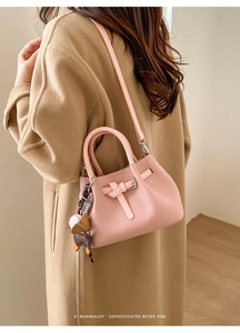 Rosa Handtasche aus Leder mit Kieselprägung, Riemenverzierung und Bären-Anhänger