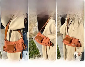 Detail of orange suede crossbody bag with multiple pockets and adjustable brown leather strap
