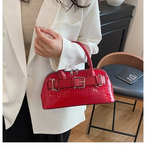 Close-up of red crocodile pattern shell bag with stylish buckle and metal zippers