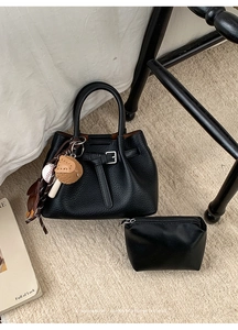 Schwarze Schultertasche aus genarbtem Leder mit Dekogürtel und Baseball-Anhängern