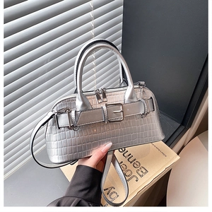 Detail of silver crocodile pattern shell bag with metal buckle and top handle