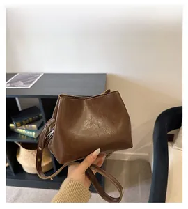 Detailed view of dark brown faux leather handbag with embossed FASHION lettering