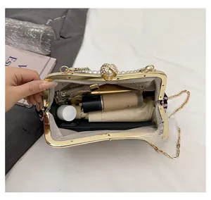 Detail view of floral embroidery evening bag showing storage capacity for makeup and phone